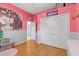 Bedroom featuring pink walls, wood floors, a closet, and white trim at 2309 Valrico Forest Dr, Valrico, FL 33594