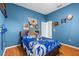 A bedroom with blue walls, wood floors, and a Lightning themed bed set at 2309 Valrico Forest Dr, Valrico, FL 33594
