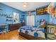 A bedroom with blue walls, wood floors, and a Lightning themed bed set and a sliding closet door at 2309 Valrico Forest Dr, Valrico, FL 33594
