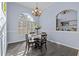 Charming dining area featuring gray wood floors, modern lighting, and a sun-drenched arched window at 2309 Valrico Forest Dr, Valrico, FL 33594