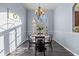 Bright dining room boasts modern chandelier, arched window, and sleek flooring at 2309 Valrico Forest Dr, Valrico, FL 33594