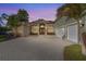 Elegant home with stone accents, arched windows, and a lush front yard at twilight at 2309 Valrico Forest Dr, Valrico, FL 33594