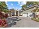 Stunning home featuring a paver driveway, manicured landscaping, and a three-car garage at 2309 Valrico Forest Dr, Valrico, FL 33594