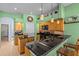 Bright kitchen features light wood cabinets, black countertops and appliances, and island with sink at 2309 Valrico Forest Dr, Valrico, FL 33594
