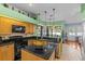 Bright kitchen features black countertops, matching appliances, breakfast bar and casual dining area overlooking pool at 2309 Valrico Forest Dr, Valrico, FL 33594