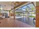 Inviting covered pool area with tile patio, wood deck, and lush landscaping, perfect for outdoor relaxation at 2309 Valrico Forest Dr, Valrico, FL 33594