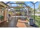 Covered patio with wood deck leads to a screened-in pool offering a perfect blend of indoor-outdoor living at 2309 Valrico Forest Dr, Valrico, FL 33594