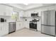 Modern kitchen features stainless steel appliances, white cabinetry, stone countertops and hardware, with tile floors for easy maintenance at 2646 Barksdale Ct, Clearwater, FL 33761