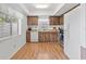 A traditional kitchen featuring wood cabinets, white appliances, laminate flooring, and a window over the kitchen sink at 2646 Barksdale Ct, Clearwater, FL 33761