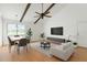 Bright living room with beamed vaulted ceiling, a ceiling fan, light-colored walls, and hardwood floors is ready for your decorating touch! at 2646 Barksdale Ct, Clearwater, FL 33761
