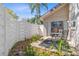 Private outdoor patio area with seating, enclosed by a white fence and lush landscaping at 2646 Barksdale Ct, Clearwater, FL 33761
