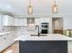 Modern kitchen featuring white cabinets, stainless appliances, and stylish pendant lighting at 2827 W Bay Haven Dr, Tampa, FL 33611