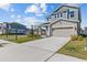 Two story home featuring a front yard and two car garage with a paved driveway at 28889 Orange Berry # Dr, Wesley Chapel, FL 33543