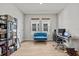 Bright office with a blue couch, an adjustable desk and plenty of natural light streaming through two windows at 28889 Orange Berry # Dr, Wesley Chapel, FL 33543