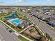 Aerial view of community pool and playground in neighborhood, with modern homes nearby at 28889 Orange Berry # Dr, Wesley Chapel, FL 33543