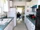 Galley-style kitchen with white cabinets, and a view into an adjacent room at 2960 59Th S St # 501, Gulfport, FL 33707