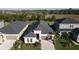 Aerial view of a well-maintained home with a dark roof and lush landscaping at 33410 Castaway Loop, Wesley Chapel, FL 33543