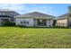 This backyard features a large manicured lawn and black metal fence surrounding the property at 33410 Castaway Loop, Wesley Chapel, FL 33543