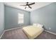 This bedroom features blue walls, a ceiling fan, carpeted floors and a window for natural light at 33410 Castaway Loop, Wesley Chapel, FL 33543