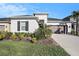 Single-story home with a landscaped front yard, two-car garage, and black window shutters at 33410 Castaway Loop, Wesley Chapel, FL 33543