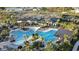 Aerial view of a luxurious resort style pool area with lounge chairs and palm trees at 33410 Castaway Loop, Wesley Chapel, FL 33543