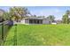 Expansive backyard features a large lawn, screened patio, and mature trees at 3629 Mossy Oak Cir, Land O Lakes, FL 34639