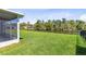 Expansive backyard featuring lush green lawn and tranquil water view, enclosed with a black fence at 3629 Mossy Oak Cir, Land O Lakes, FL 34639