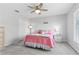 Cozy bedroom features a decorative bed, ceiling fan, carpet, and a light-filled window at 3629 Mossy Oak Cir, Land O Lakes, FL 34639