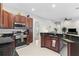 Eat-in kitchen featuring granite countertops, stainless steel appliances, and dark wood cabinets at 3629 Mossy Oak Cir, Land O Lakes, FL 34639