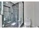 This modern bathroom showcases a glass-enclosed shower with sleek dark tile and pebble floor at 370 S Woodlands Dr, Oldsmar, FL 34677