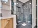This is a modern bathroom showcasing a glass-enclosed shower with sleek dark tile and pebble floor at 370 S Woodlands Dr, Oldsmar, FL 34677