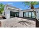 Paver patio with tall palm tree, slider door entry, and natural light at 370 S Woodlands Dr, Oldsmar, FL 34677