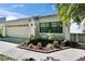 Single-Gathering home featuring a two-car garage and landscaped garden at 370 S Woodlands Dr, Oldsmar, FL 34677