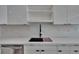 Modern kitchen features black sink and marble countertops and stainless dishwasher at 370 S Woodlands Dr, Oldsmar, FL 34677