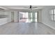 Open-concept living room featuring light wood floors, access to the kitchen, and an outdoor patio at 370 S Woodlands Dr, Oldsmar, FL 34677