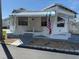 Exterior view of a quaint mobile home featuring awnings, stairs and an American flag at 4851 W Gandy Blvd # B1L14, Tampa, FL 33611