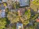 An aerial view displays a property with a brown roof, a nearby pool, mature trees, and a well-kept, green lawn at 4950 26Th N Ave, St Petersburg, FL 33710