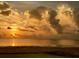 A golden sunset over the water, with dramatic cloud formations filling the sky from this beautiful beach at 5133 Glenn Dr, New Port Richey, FL 34652