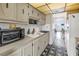 Functional kitchen with white cabinets, white appliances, and a view into the living area of the house at 5347 81St N Ln # 25, St Petersburg, FL 33709