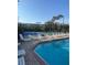 Community pool with lounge chairs and view of tennis court at 540 Somerhill Ne Dr, St Petersburg, FL 33716