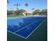 Well-maintained blue tennis courts with a nearby clubhouse and lounge chairs at 540 Somerhill Ne Dr, St Petersburg, FL 33716