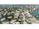 Aerial view of waterfront neighborhood showing the property, marked by an arrow, close to boat docks and other residential homes at 596 S Bayshore Dr, Madeira Beach, FL 33708