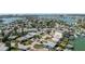 Attractive aerial view of homes with docks, canal access, and the open ocean in the distance at 596 S Bayshore Dr, Madeira Beach, FL 33708