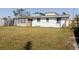 Expansive backyard showing the home exterior and enclosed porch, ideal for outdoor activities at 596 S Bayshore Dr, Madeira Beach, FL 33708