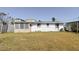 Wide-open backyard with a partial view of a back side exterior of the house and an enclosed porch at 596 S Bayshore Dr, Madeira Beach, FL 33708