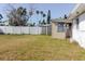 Fenced backyard with overgrown grass, offering a private outdoor space ready for landscaping and customization at 596 S Bayshore Dr, Madeira Beach, FL 33708