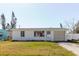 Well-kept exterior with a garage, set against a backdrop of lush greenery and a clear blue sky at 596 S Bayshore Dr, Madeira Beach, FL 33708
