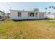 Single-story home with white exterior, a small front yard, and an attached one-car garage at 596 S Bayshore Dr, Madeira Beach, FL 33708