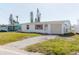 Classic home with a garage and driveway surrounded by green grass and foliage at 596 S Bayshore Dr, Madeira Beach, FL 33708