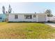 Quaint home with garage, complemented by vibrant green lawn and clear blue sky at 596 S Bayshore Dr, Madeira Beach, FL 33708